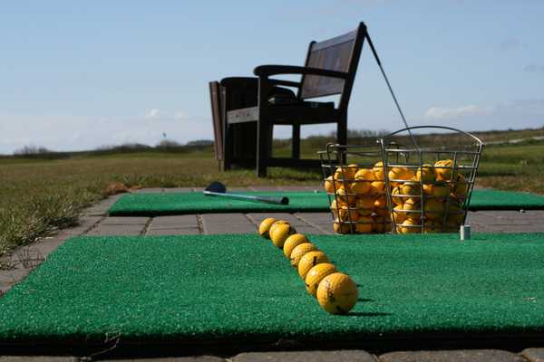 Line of golfballs waiting to be hit
